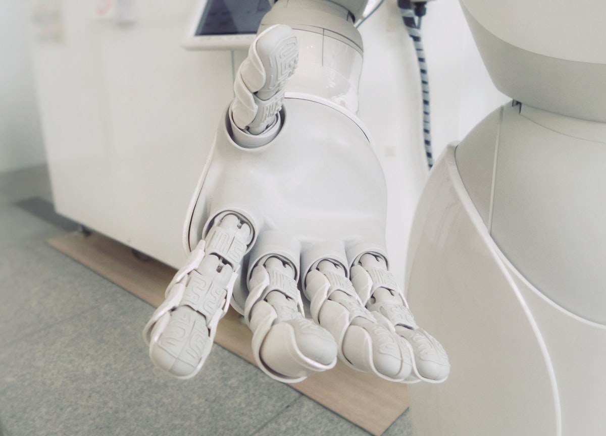 Close-up of a white robotic hand reaching forward, representing approachable, practical AI tools