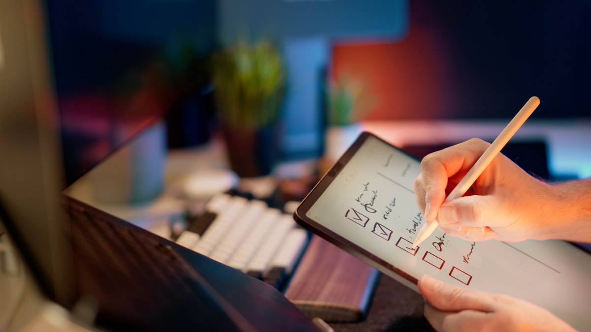 Hand checking off boxes on a tablet checklist
